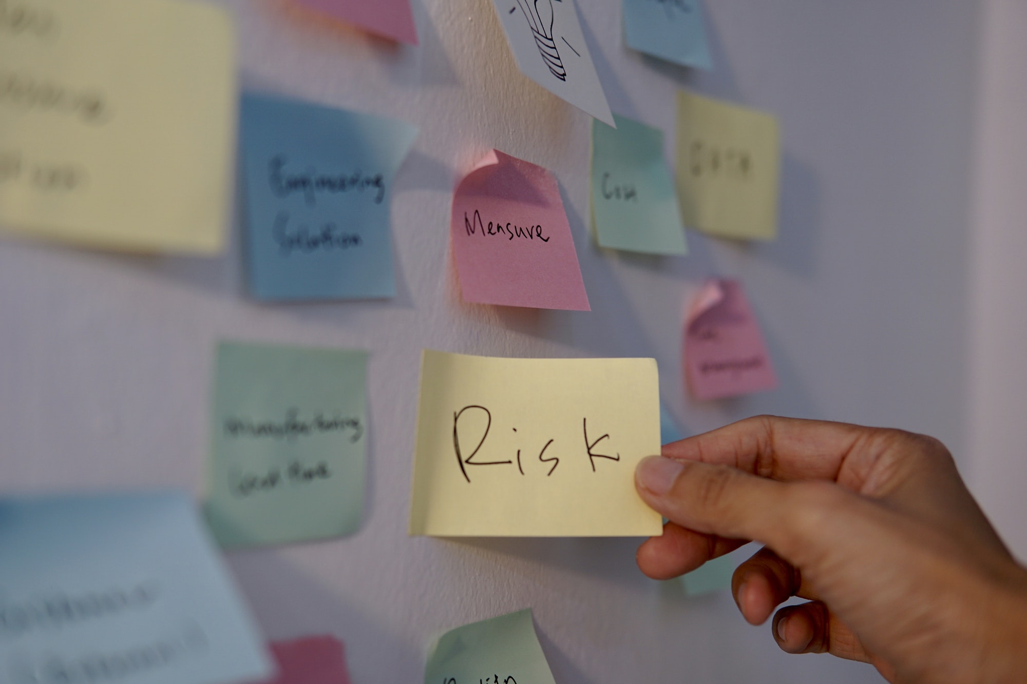 Brainstorming discussion in the office, sticky notes on the board, ideas, risk assessment